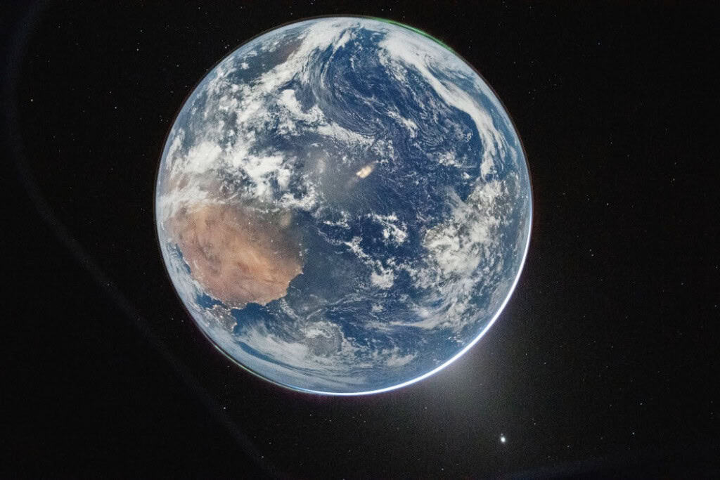 imagem da terra com estrelas ao redor e vênus ao fundo. foi tirada pela missão artemis 2