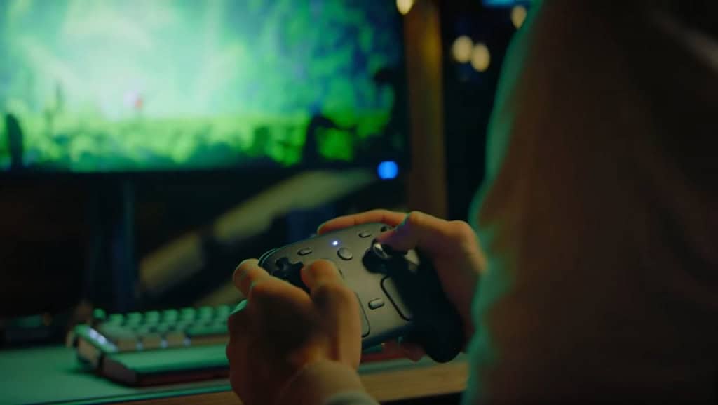 imagem mostra um homem jogando videogame no pc com o steam controller