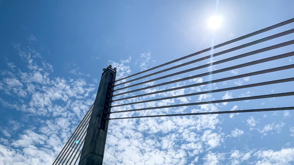 Céu azul e Sol, com ponte a frente na imagem