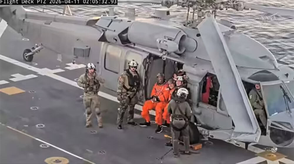 Astronauta Victor Glover sentado na porta de um helicóptero