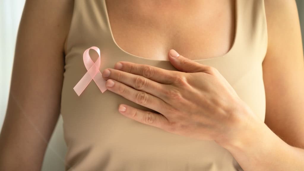 Mulher usando broche com laço que simboliza câncer de mama