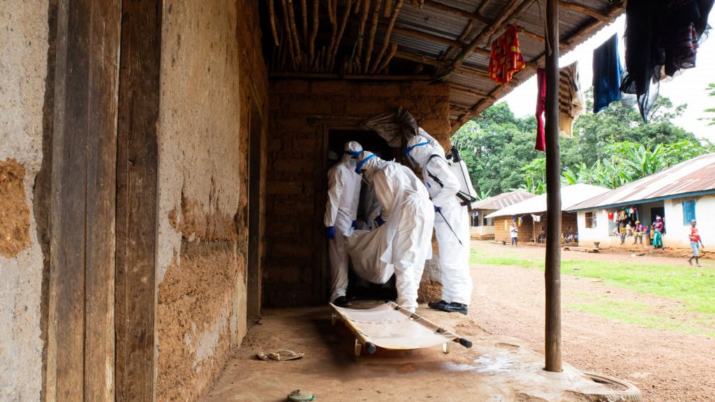 Profissionais de saúde recolhendo paciente com ebola na África