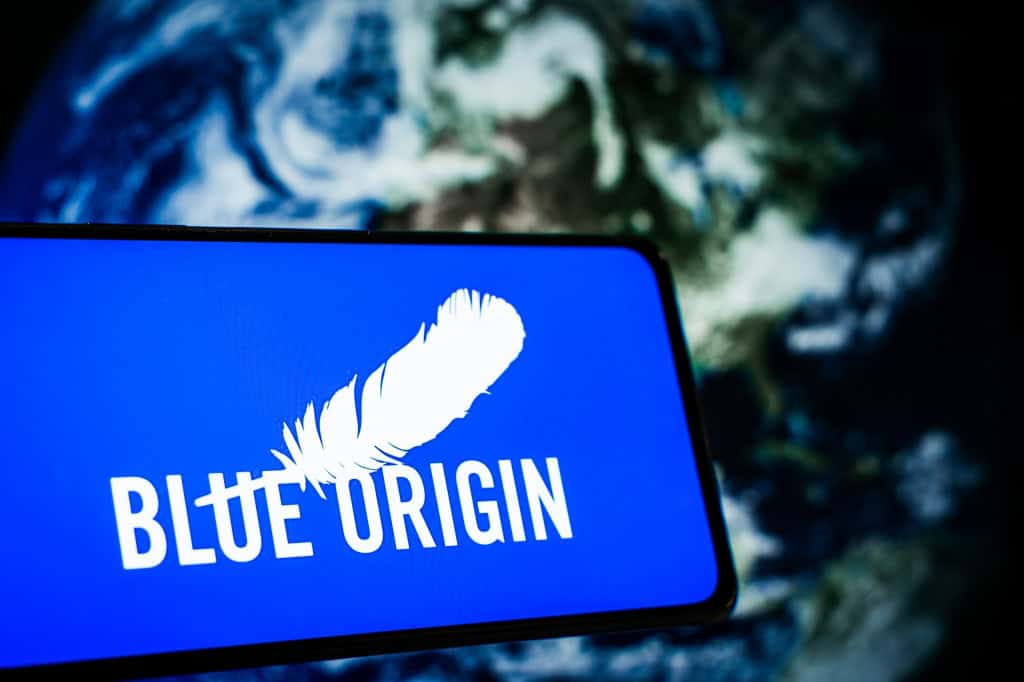 Ao fundo, imagem da Terra vista do espaço; à frente, logo da Blue Origin em um smartphone