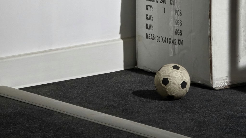 imagem mostra uma bola de futebol atrás de uma parede