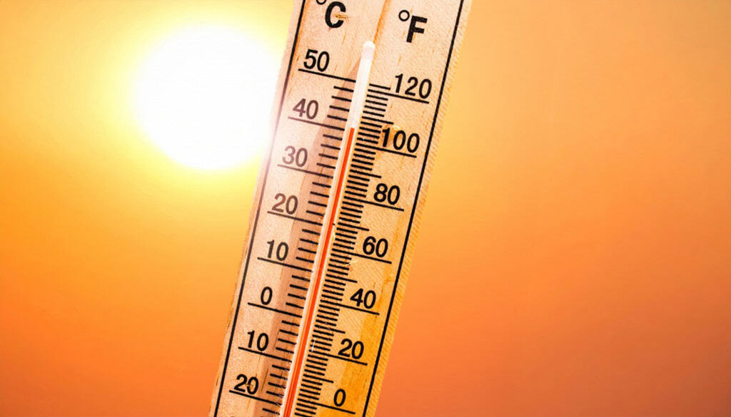 Termômetro marca temperatura elevada sob sol forte em imagem que representa calor extremo.