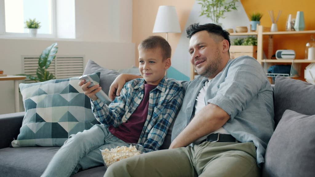 Pai e filho assistindo a um filme em um serviço de streaming