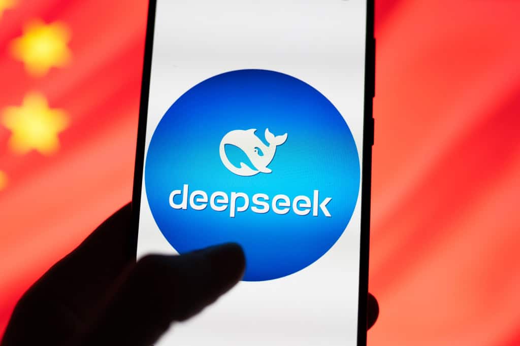 Ao fundo, bandeira da China; à frente, logo da DeepSeek em um smartphone