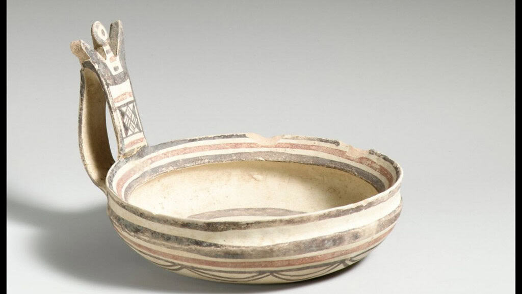 imagem mostra uma bacia de cerâmica com listras coloridas e a figura antropomorfica de um homem