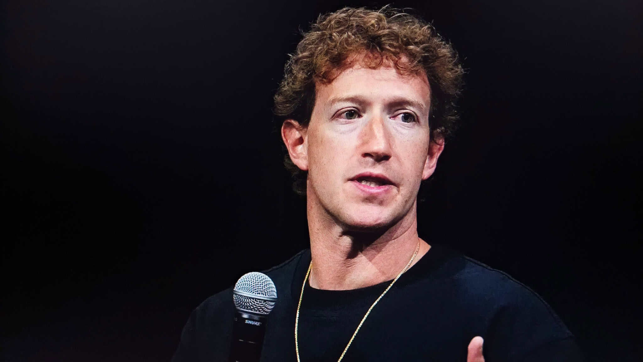 Mark Zuckerberg com um microfone na mão e falando