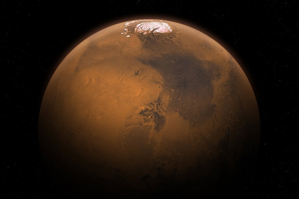Planeta Marte visto do espaço, com superfície avermelhada, crateras e uma calota polar branca no topo