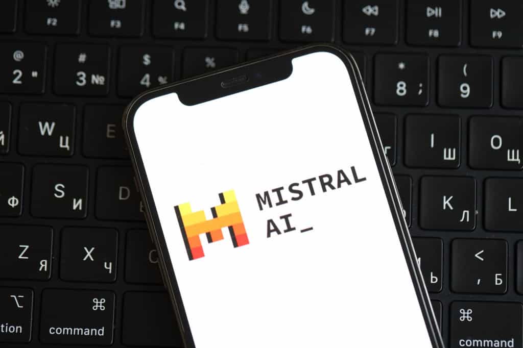 Logo da Mistral na tela de um smartphone em cima de um teclado de computador