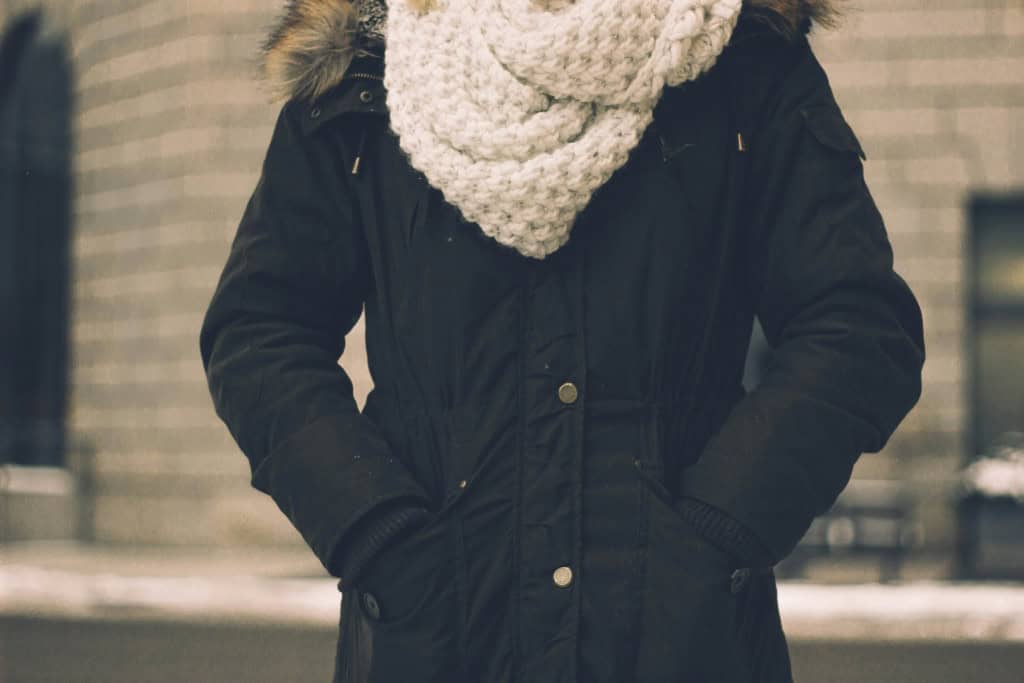 Mulher com frio no meio da cidade