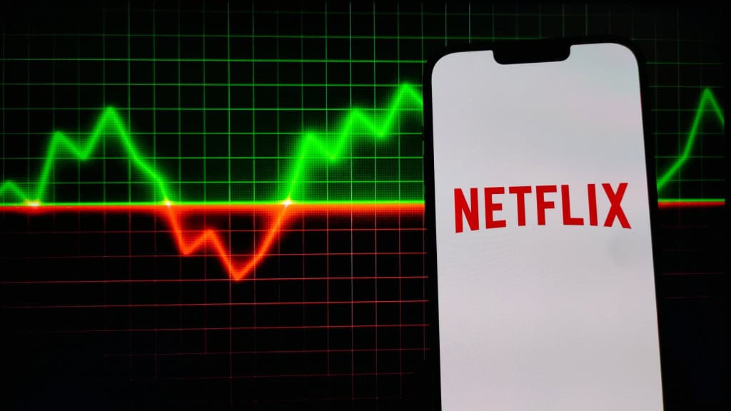 Ao fundo, gráfico financeiro; à frente, logo da Netflix em um smartphone