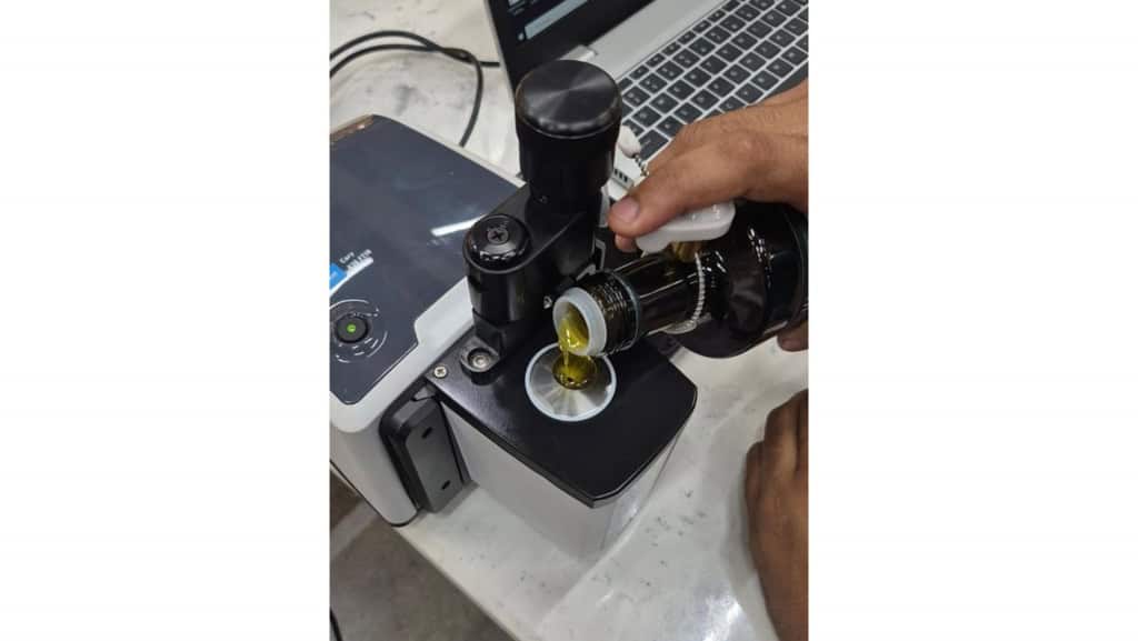 Perito técnico analisando uma amostra de azeite em laboratório