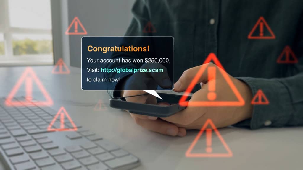 Empresário segurando o telefone com a mensagem scam na tela digital.