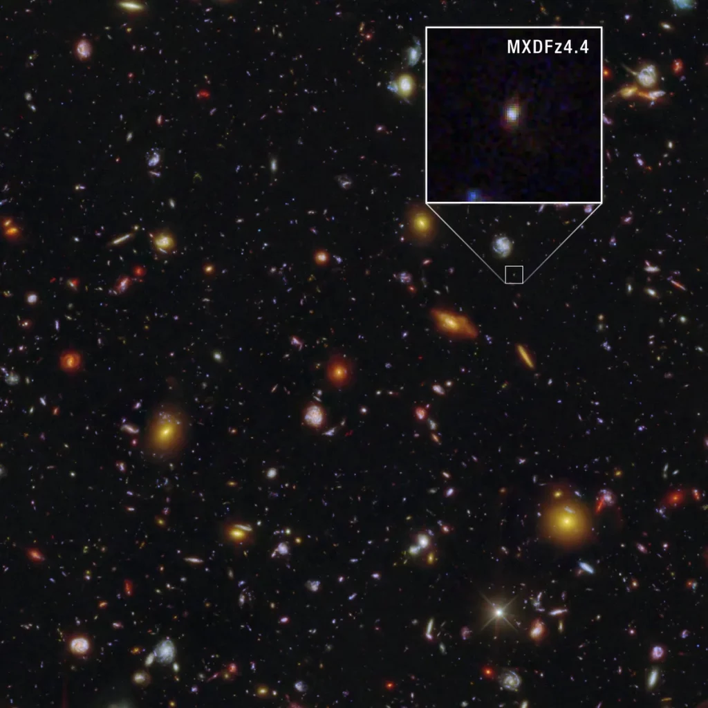 A visão completa do Telescópio Espacial Hubble de MXDFz4.4 e seus arredores a partir do nosso ponto de observação.