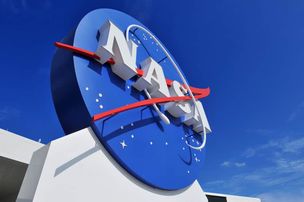 Logo da NASA, visto de baixo para cima, em frente a um prédio