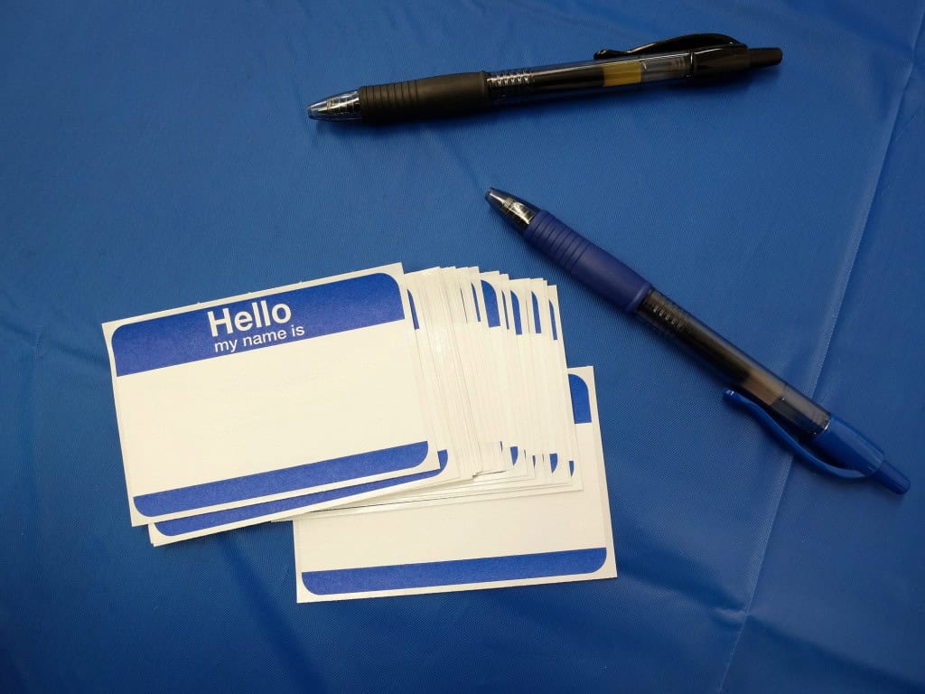 Existe mesmo “cara de Ana” ou “cara de João”? Estudo responde 7 Etiqueta de identificação com a frase 'hello my name is' ao lado de uma caneta sobre mesa madeira.