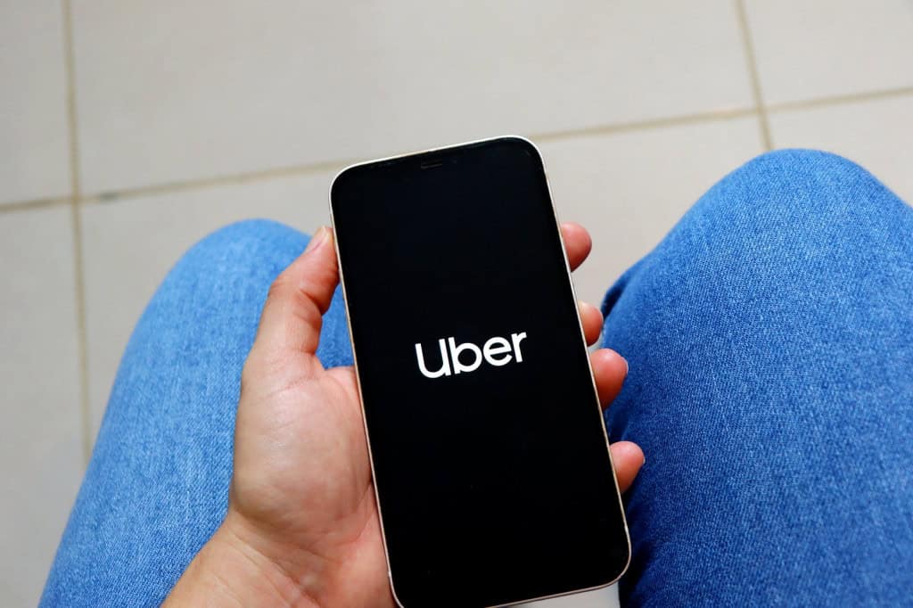 Logo da Uber em um smartphone na mão