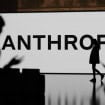 Logo da Anthropic em uma parede com pessoas ao redor