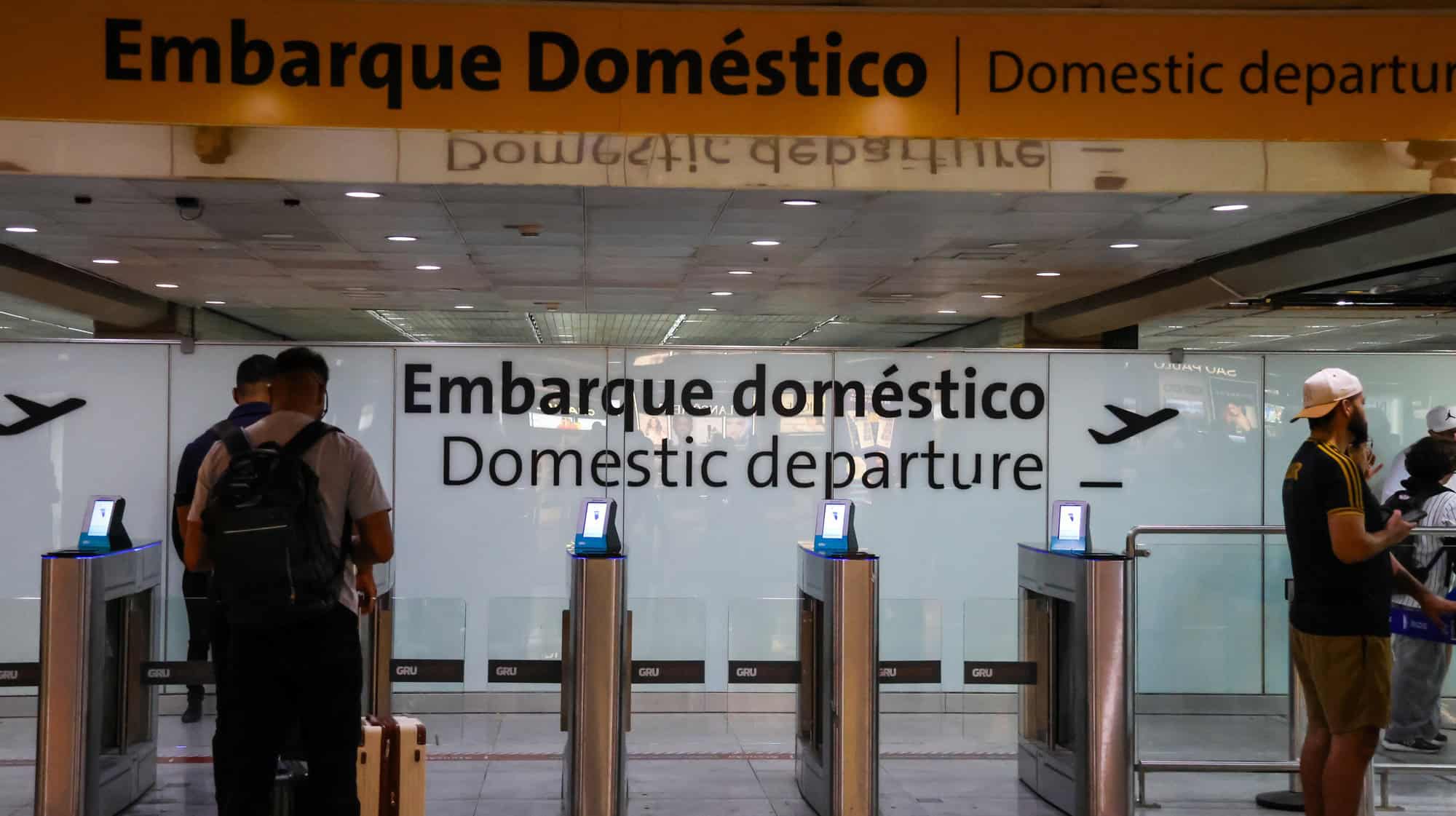 Uma fotografia de uma área de controle de segurança e portões de embarque no Aeroporto de Guarulhos (GRU)