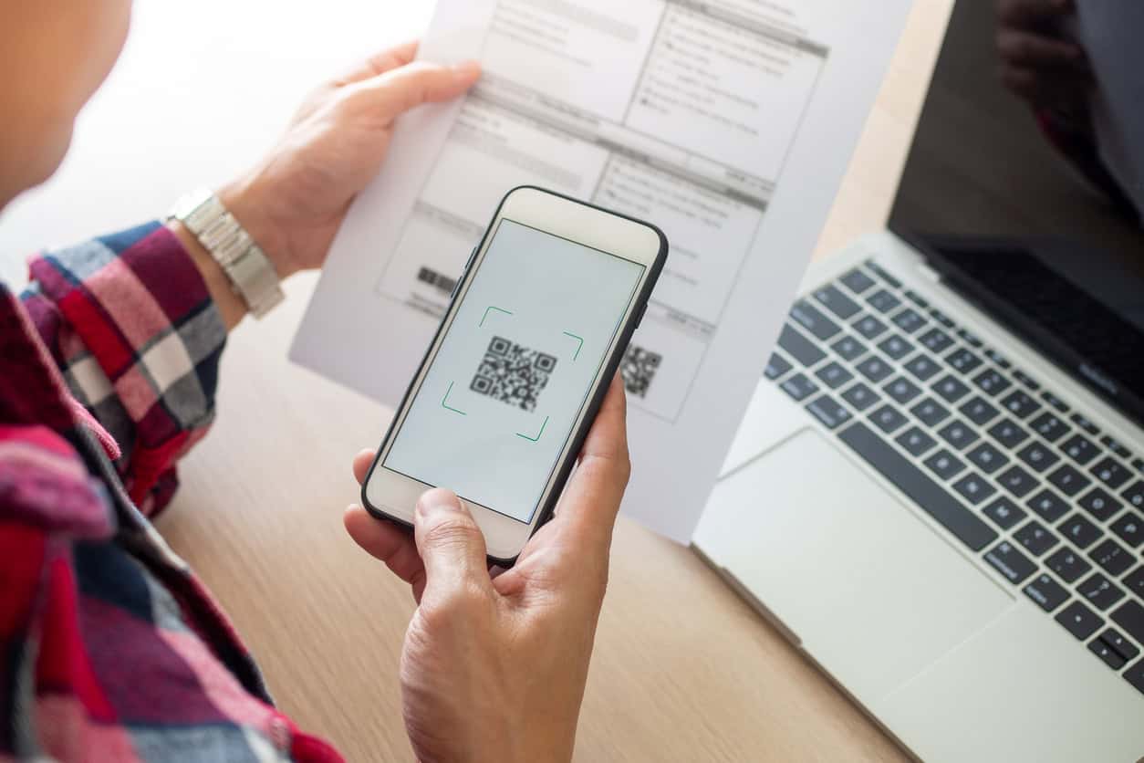 Homem usando um celular para escanear o código QR da conta pelo aplicativo.