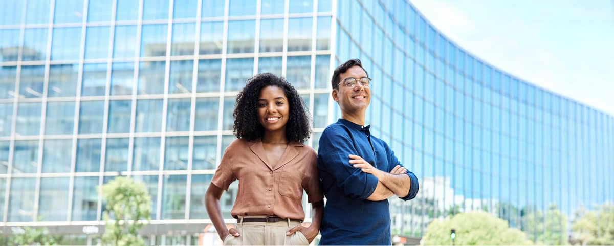 Homem e mulher em frente a um prédio empresarial