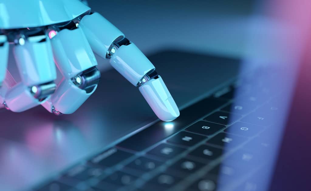 Mão robótica interage com o teclado de um computador, representando agentes de inteligência artificial e automação digital.