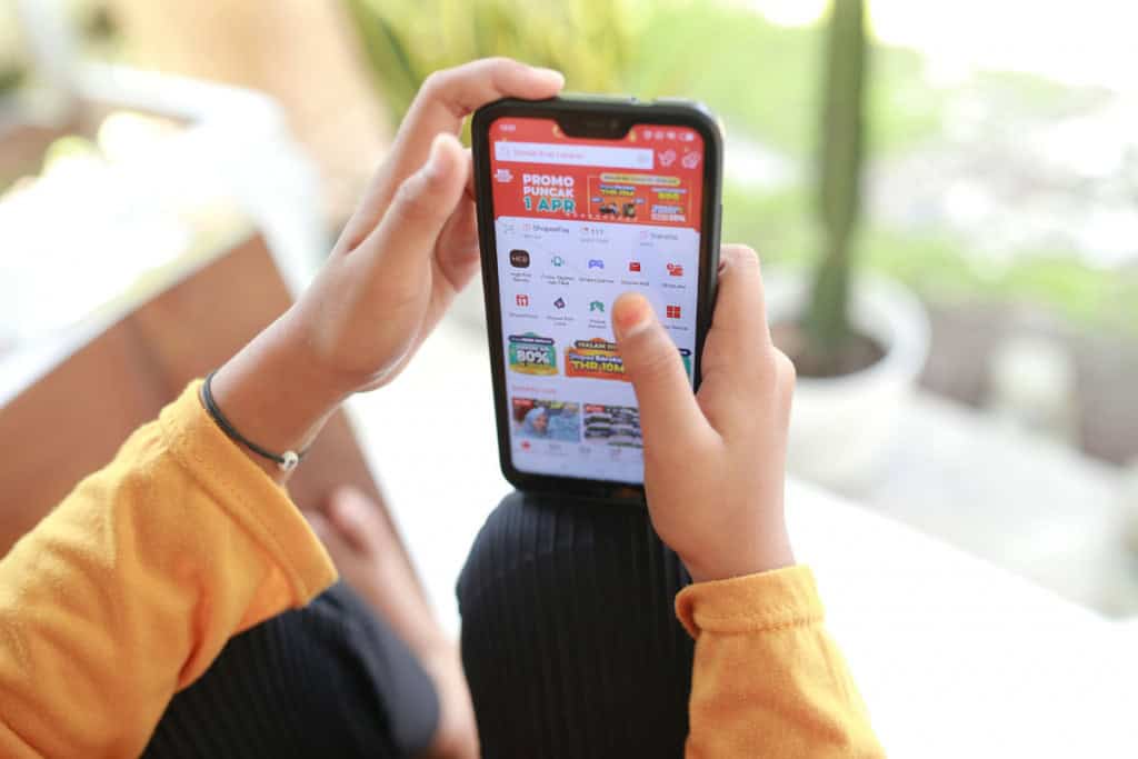 Mulher usando o aplicativo Shopee em smartphones