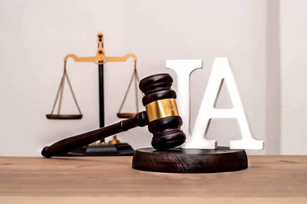 Martelo de juiz sobre mesa de madeira, com uma balança da Justiça ao fundo e a letra “IA” em destaque, representando a regulamentação da inteligência artificial.