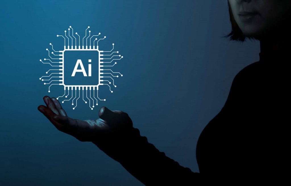 Silhueta de uma pessoa segurando um ícone de chip de IA digital contra um fundo azul, simbolizando conceitos de tecnologia e inteligência artificial.