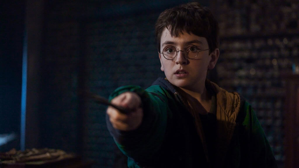 Dominic McLaughlin como Harry Potter segurando uma varinha em cena da série