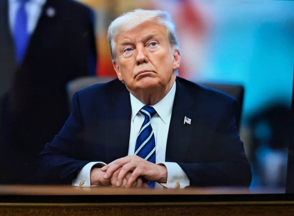 Donald Trump sentado em frente a uma mesa