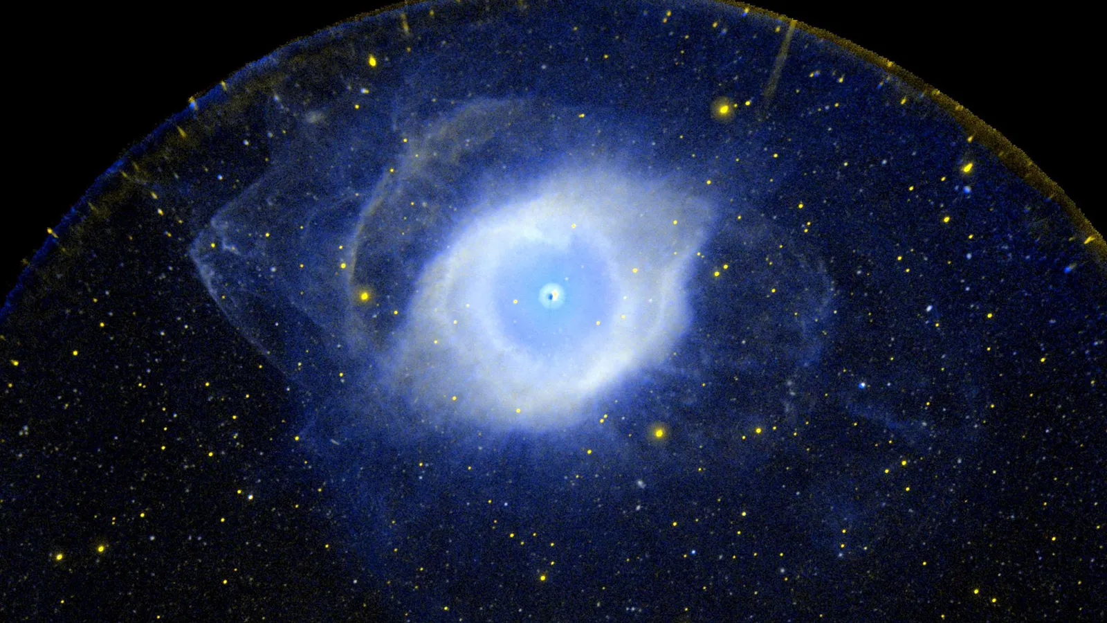 A infame Nebulosa da Hélice, fotografada aqui pela sonda Galaxy Evolution Explorer da NASA, está localizada no coração da constelação de Aquário. Ainda mais distante — além da borda da Via Láctea — astrônomos do Observatório Vera C. Rubin d