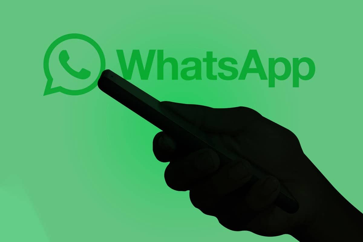 Homem usando um smartphone com o logo do WhatsApp ao fundo.