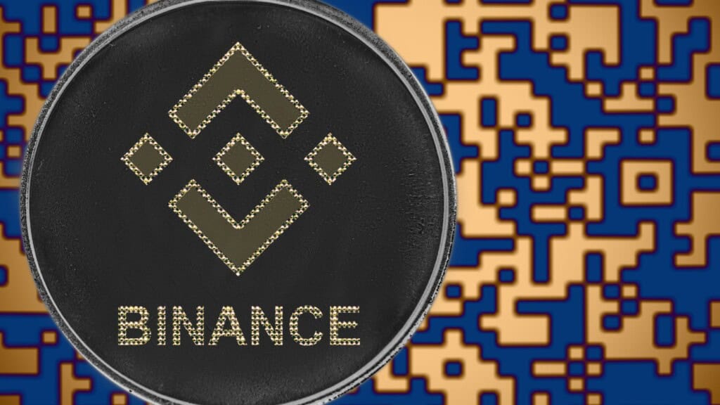 Montagem com logomarca da Binance na frente de background de código de programação