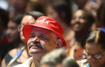 Homem usando chapéu vermelho com "Lula 13" escrito