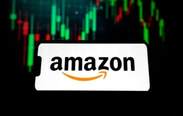 Ao fundo, gráficos financeiros; à frente, logo da Amazon na tela de um smartphone