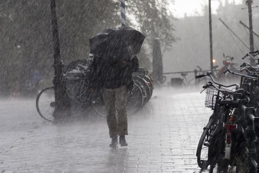 homem andando sob temporal