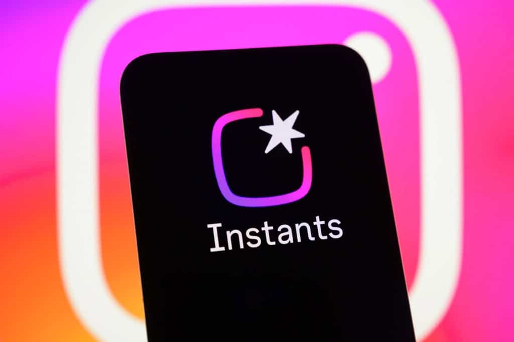 celular com o logo do Instants com logo do Instagram ao fundo