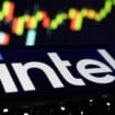 Logotipo da Intel exibido em uma tela, com um gráfico de cotações da bolsa de valores desfocado ao fundo