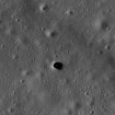Superfície da Lua com diversas crateras e uma abertura escura no centro, identificada como Marius Hills Pit.