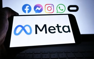 Logo da Meta à frente em um smartphone; atrás, logos das empresas da Meta