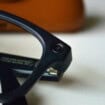 Um par de óculos inteligentes Ray-Ban Meta preto colocados em frente a uma caixa Ray-Ban de couro marrom.