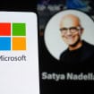 logo da microsoft em um celular em primeiro plano com perfil de rede social de satya nadella ao fundo